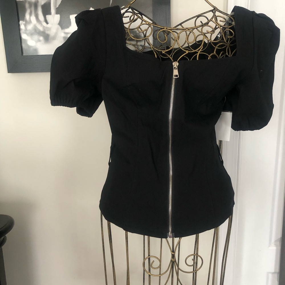 Black fitted top with puff sleeves and zipper down the front. Good stretch